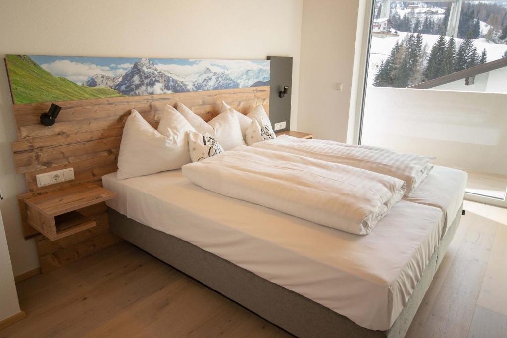 a large bed with white sheets and pillows in a bedroom at Apartment Victoria in Gries am Brenner