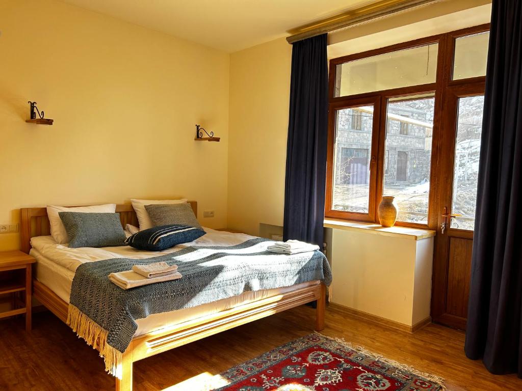 a bedroom with a bed and a window at Saryan Guesthouse in Goris