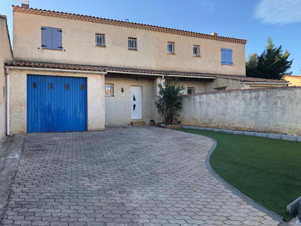 a building with a blue door and a yard at Maison la Londe in La Londe-les-Maures