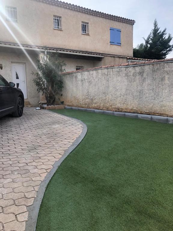 a car parked in front of a house with a lawn at Maison la Londe in La Londe-les-Maures