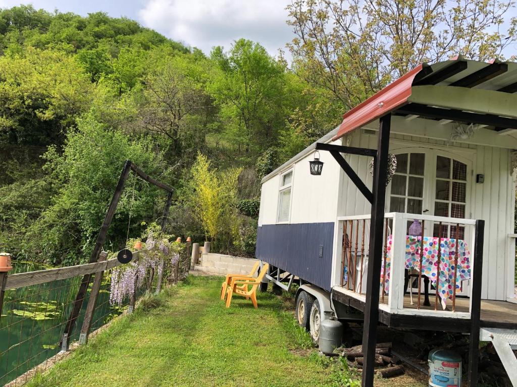 ein winziges Haus steht neben einem Haus in der Unterkunft pipowagen Blagour gelegen aan waterbron in Lachapelle-Auzac