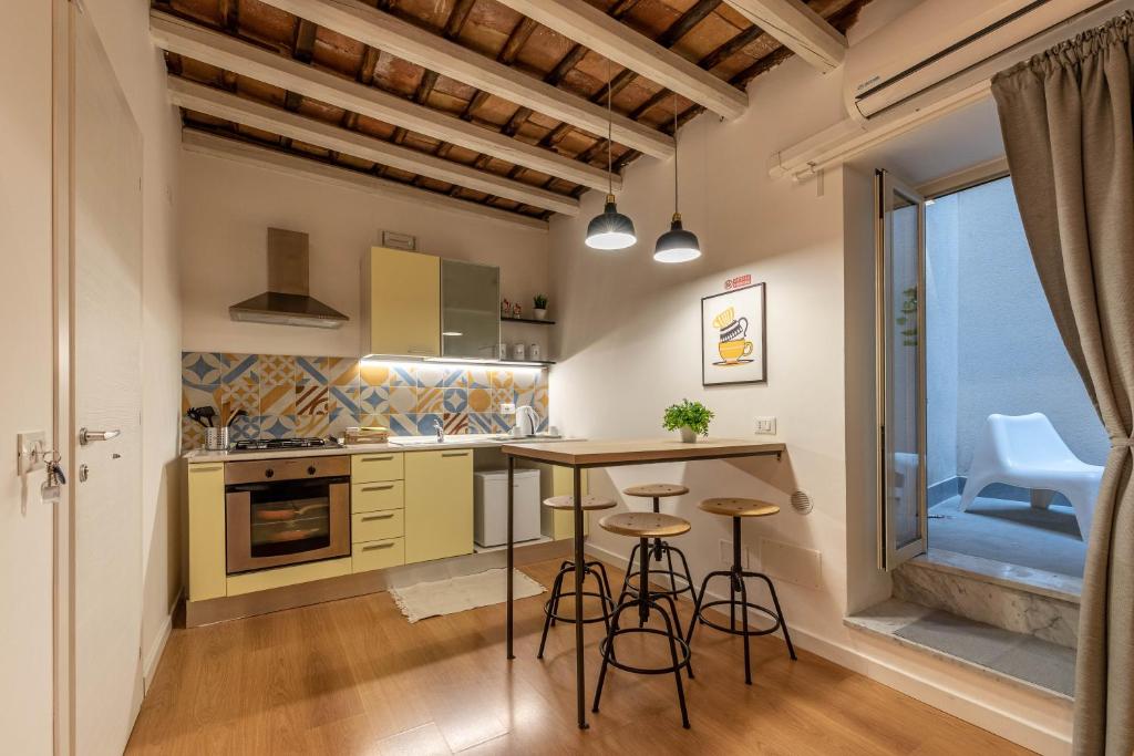 a kitchen with a table and stools in a room at Casa Abbanniata a Ballaro' in Palermo