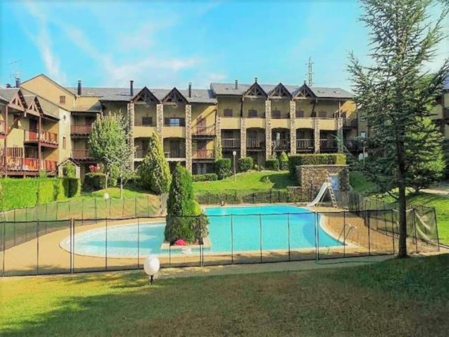 Amplio complejo de apartamentos con piscina frente a un edificio en Preciosa casa con jardín y piscina, en Bourg-Madame