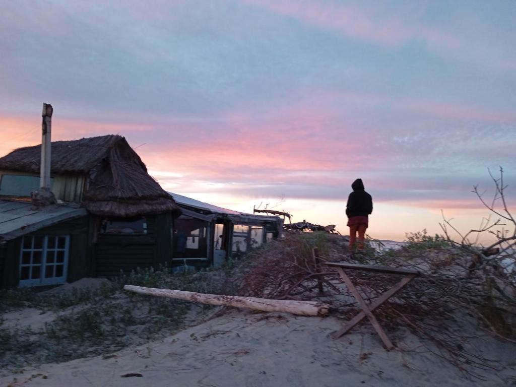 a person standing next to a house on the beach at Para un poquito oasis in Barra de Valizas