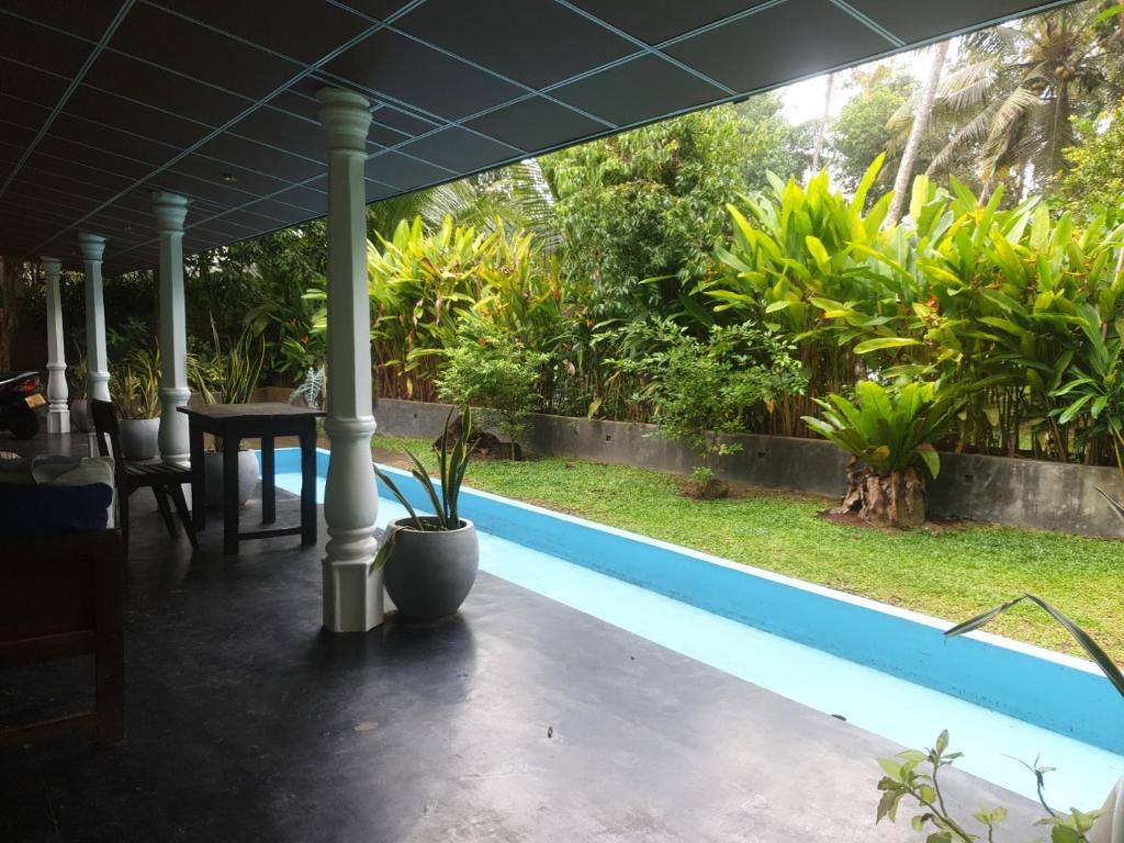 een patio met een tafel en een zwembad bij SuSha Happy Three Villa in Hikkaduwa
