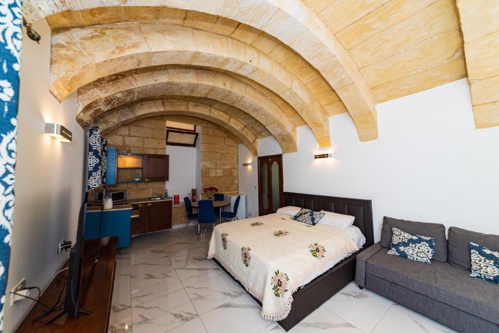 a bedroom with a bed and a couch at Valletta Old Well Apartments in Valletta