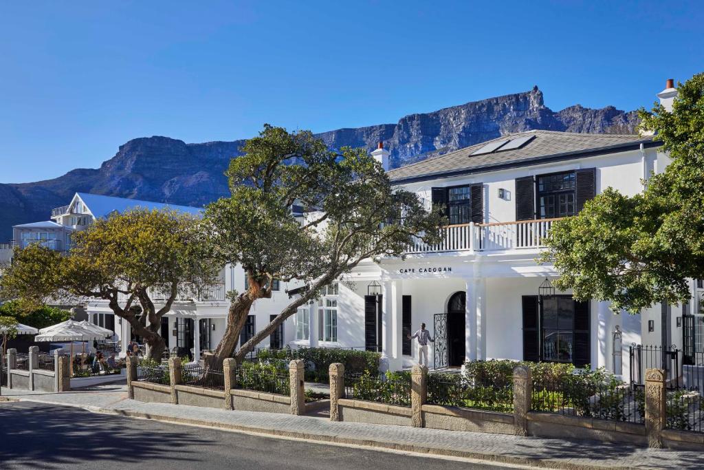 a white house with mountains in the background at Cape Cadogan Boutique Hotel in Cape Town
