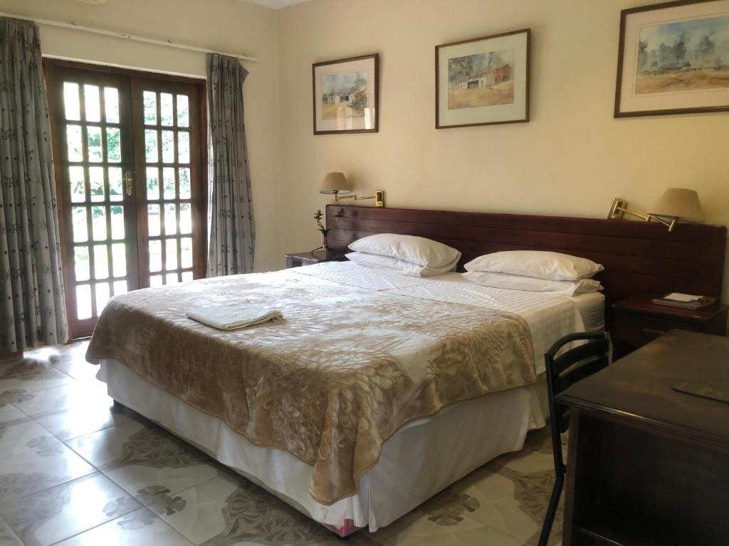 a bedroom with a large bed with white sheets at A boutique lodge situated in a serene environment - 2030 in Harare