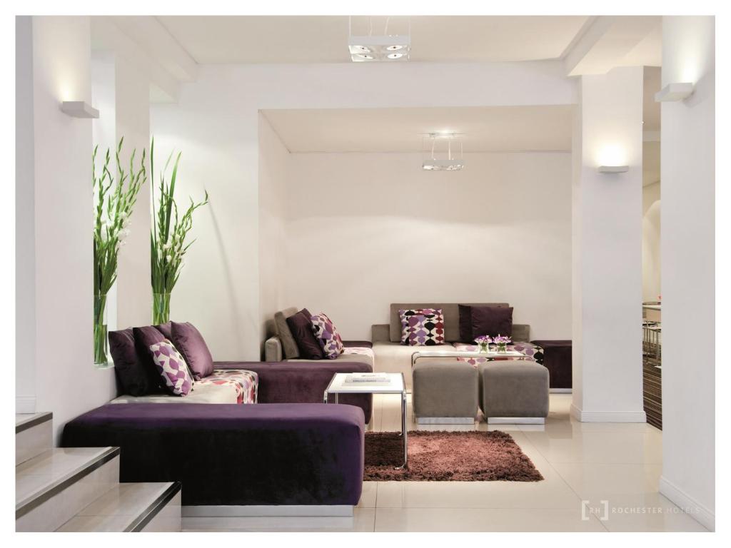 ブエノスアイレスにあるRochester Hotel Conceptの紫色のソファ2台とテーブル付きのリビングルーム
