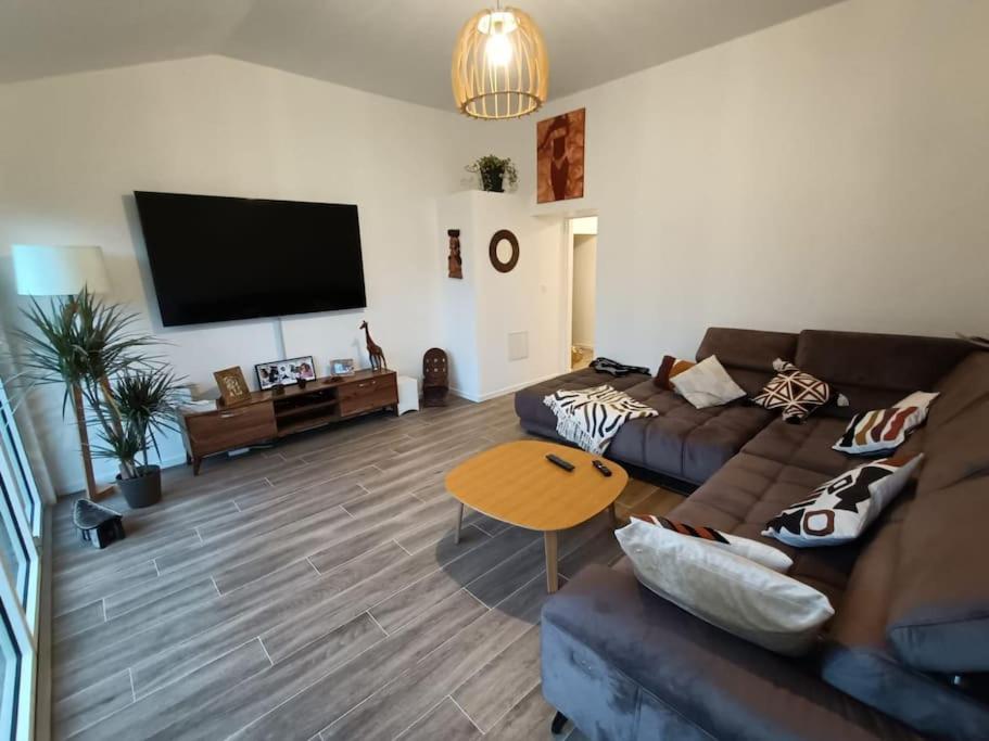 salon z kanapą i stołem w obiekcie Grande, belle maison de ville idéale 24 h du Mans w mieście Vaas