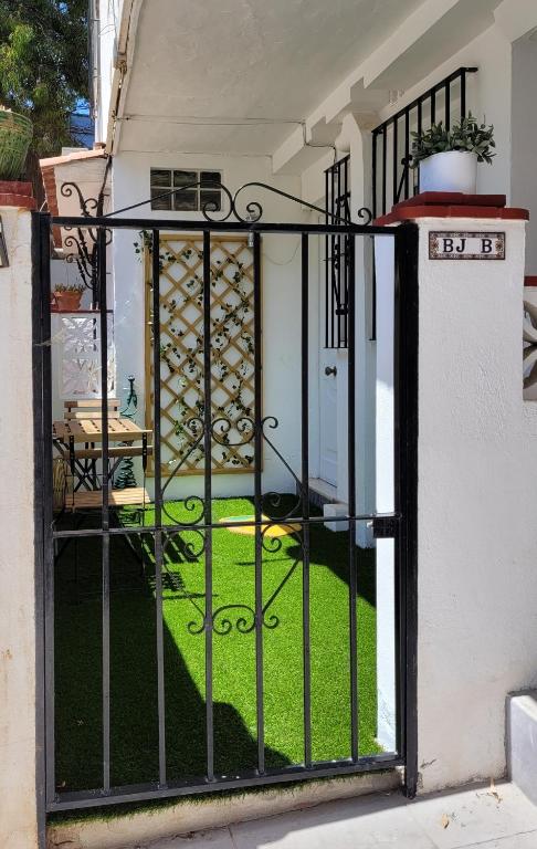 an open gate to a yard with grass at "COZY LOFT", TERRACE, PARKING and SWIMMING POOL in Málaga
