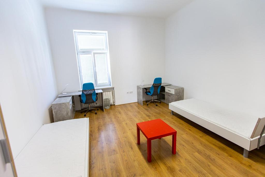 una habitación con 2 camas y un taburete rojo en Prenočišče Maribor Center, en Maribor