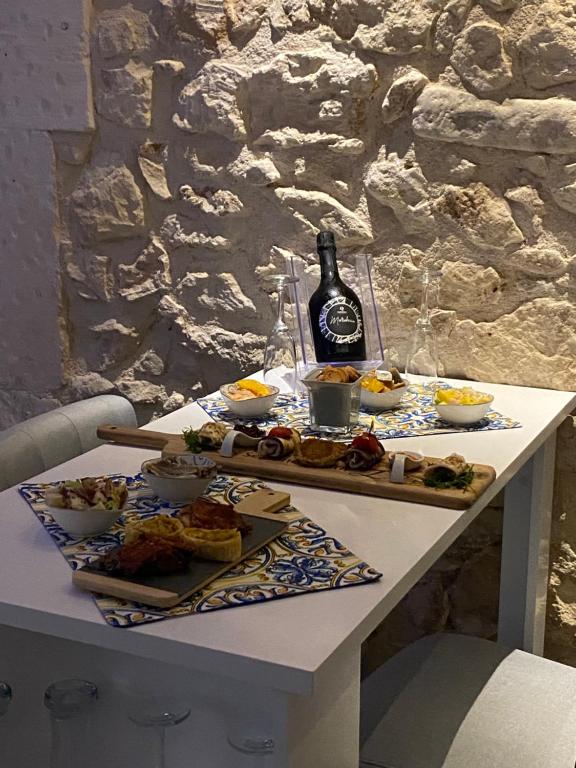 stół z jedzeniem i butelką wina w obiekcie SiricyAus Luxury Room w mieście Ragusa