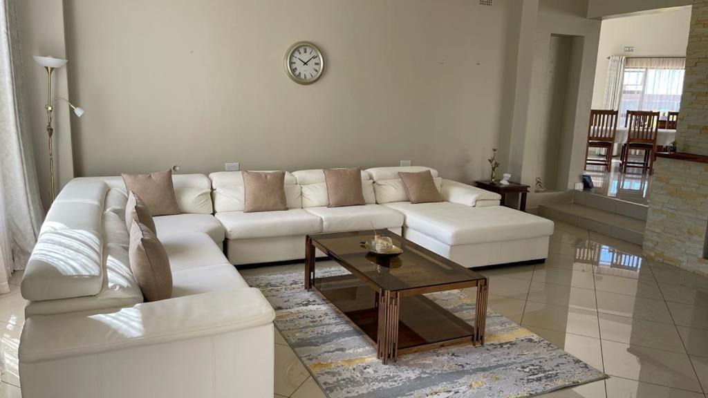 a living room with a white couch and a coffee table at Commodious and Contemporary double home - 2042 in Bulawayo