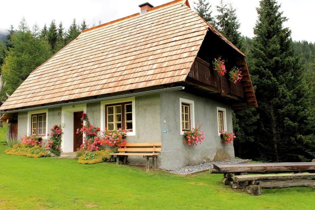 una pequeña casa con un banco delante en Droneberger-Hütte, 