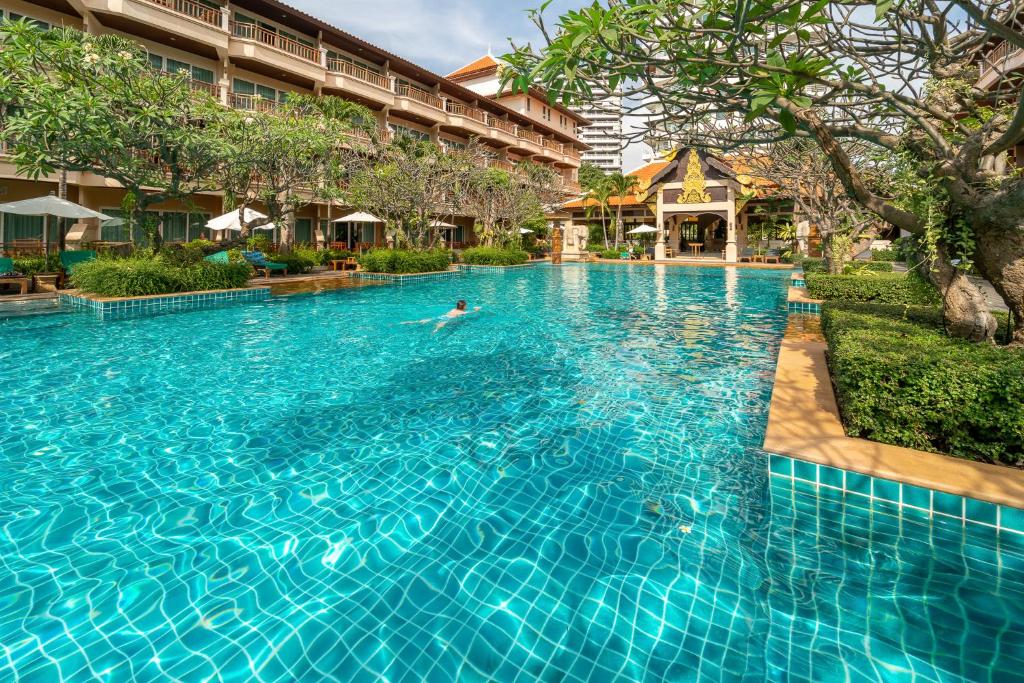 a pool at a hotel with a person swimming in it at Avalon Beach Resort in Pattaya South