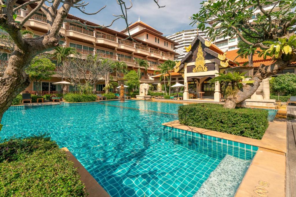 a swimming pool in front of a building at Avalon Beach Resort in Pattaya South