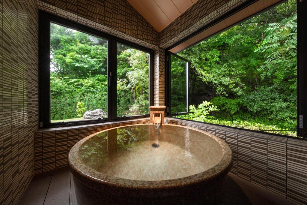 忍野村にある八海 木花館の窓付きの客室で、大きなバスタブが備わります。