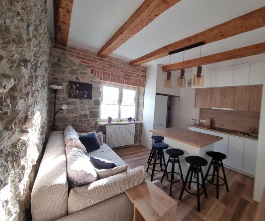 een woonkamer met een bank en een tafel bij Apartman Orhideja in Fužine