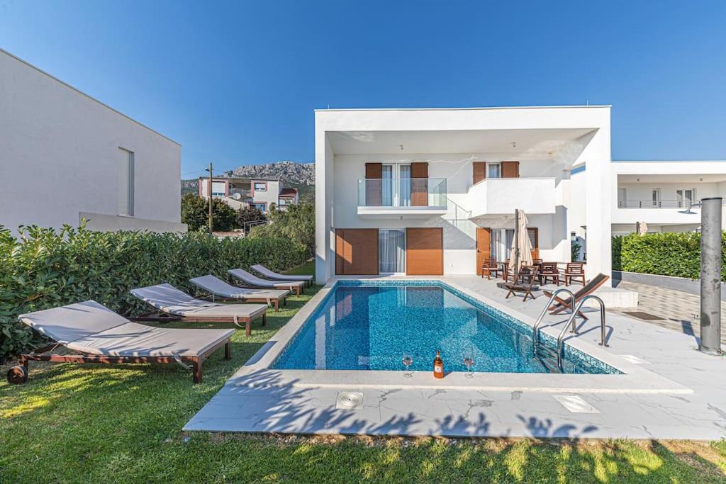 una villa con piscina accanto a un edificio di Luxury Villa Tina Moseni with private heated pool a Kaštela (Castelli)