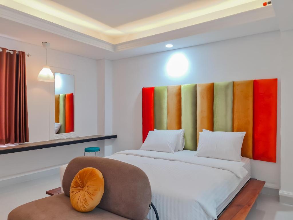 ein Schlafzimmer mit einem Bett und einem Stuhl in der Unterkunft Sans Hotel Grand Sabaraya Cikampek in Karawang