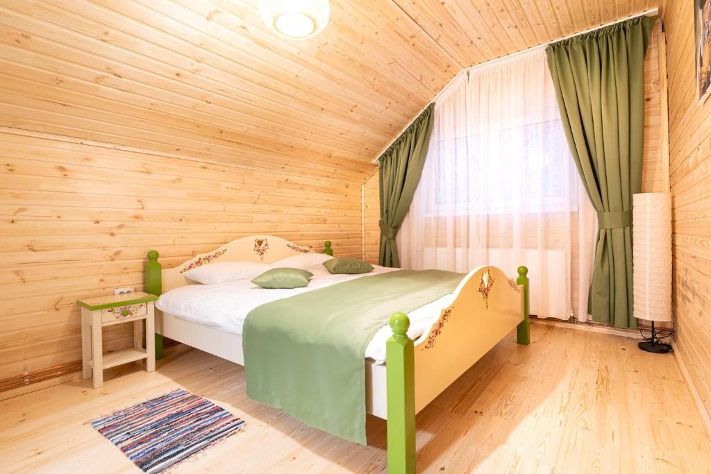 a bedroom with a bed in a wooden room at Cabana cu Flori in Porumbacu de Sus