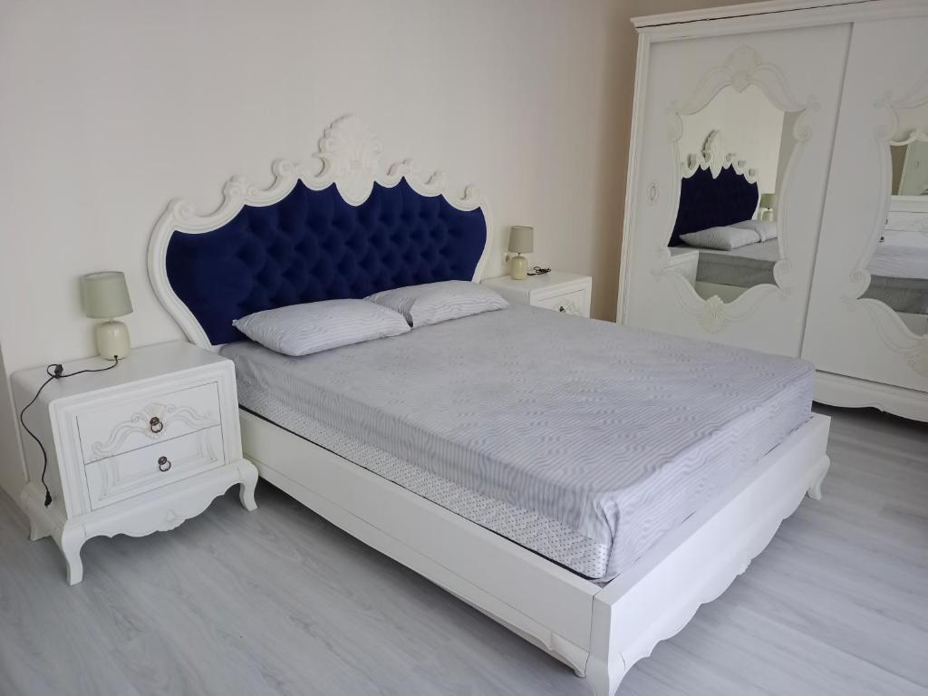 a bedroom with a large bed with a blue headboard at Pelittepe sitesi in Pelitli