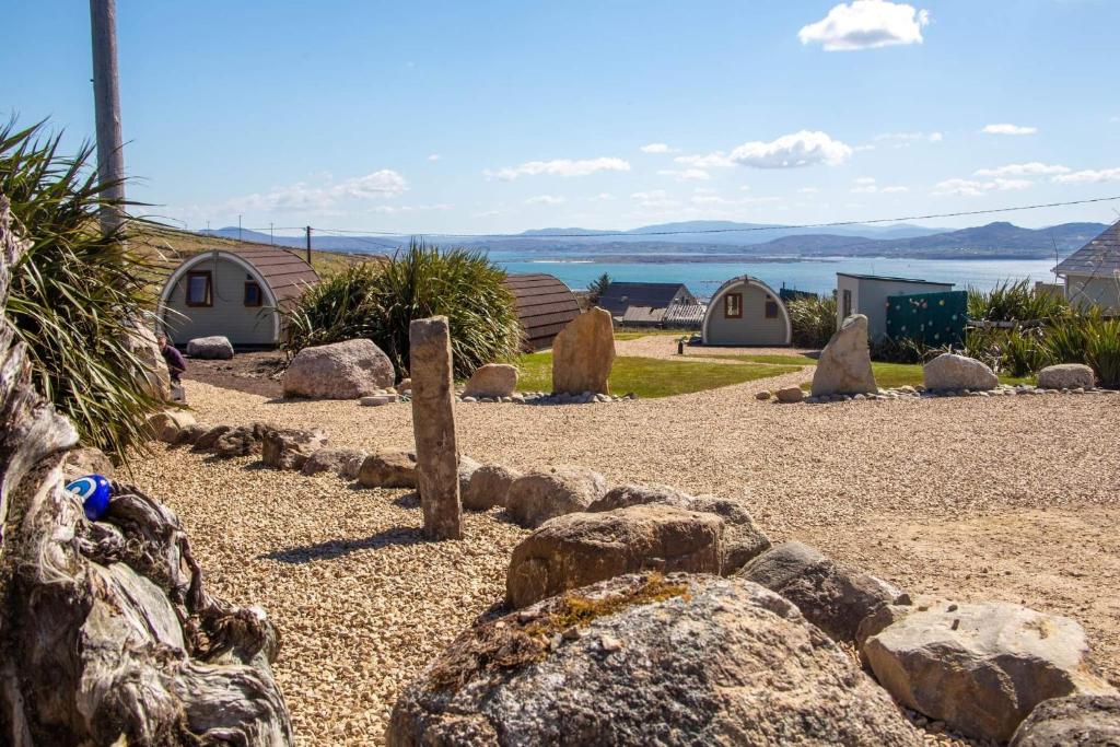 a garden with rocks and tents and a body of water at Arranmore Glamping in Aphort