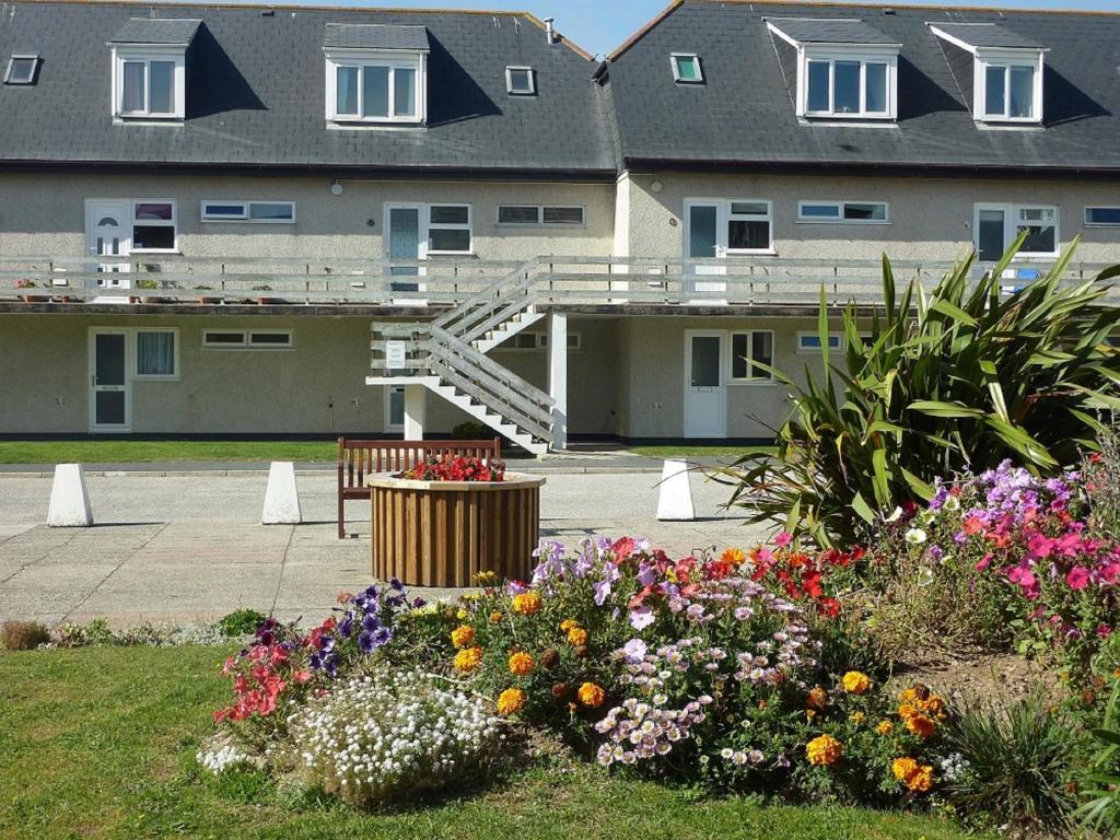 a group of flowers in front of a building at 9 Wheal Ramoth, Atlantic bay in Perranporth