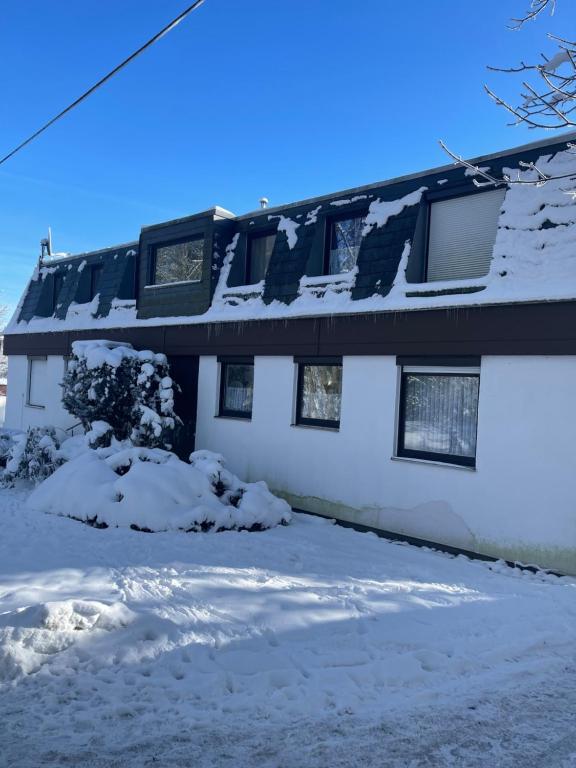 een huis met sneeuw op het dak bij Appartement an Möppis Hütte im Skigebiet in Winterberg