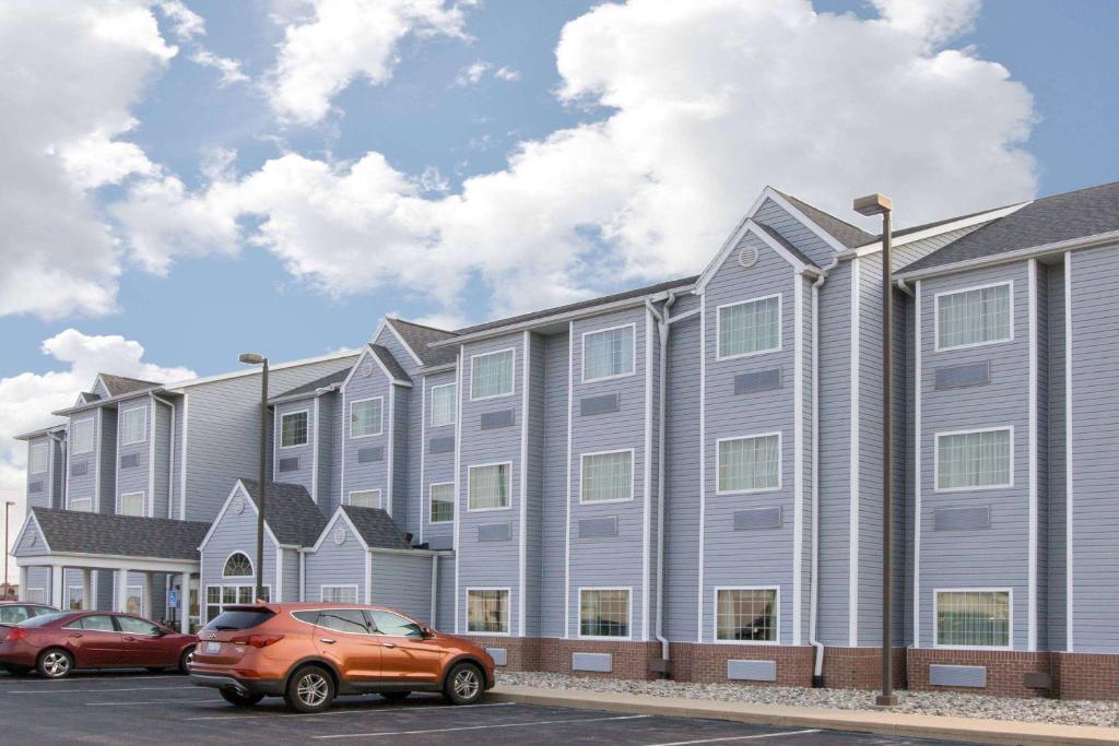 an orange car parked in front of a building at Microtel Inn & Suites by Wyndham Delphos in Delphos