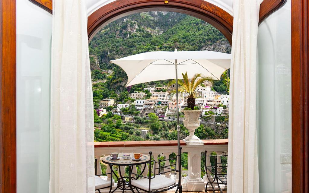 a balcony with a table and an umbrella at Villa Palumbo in Positano