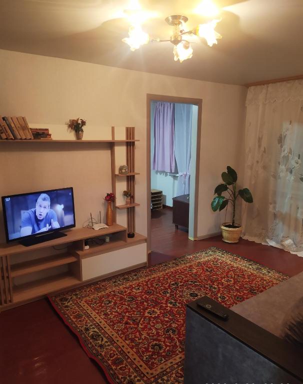 uma sala de estar com uma televisão de ecrã plano sobre uma mesa em 3-х комнатная квартира по улице Коцюбинского, дом 9 дробь 6 em Kremenchuk