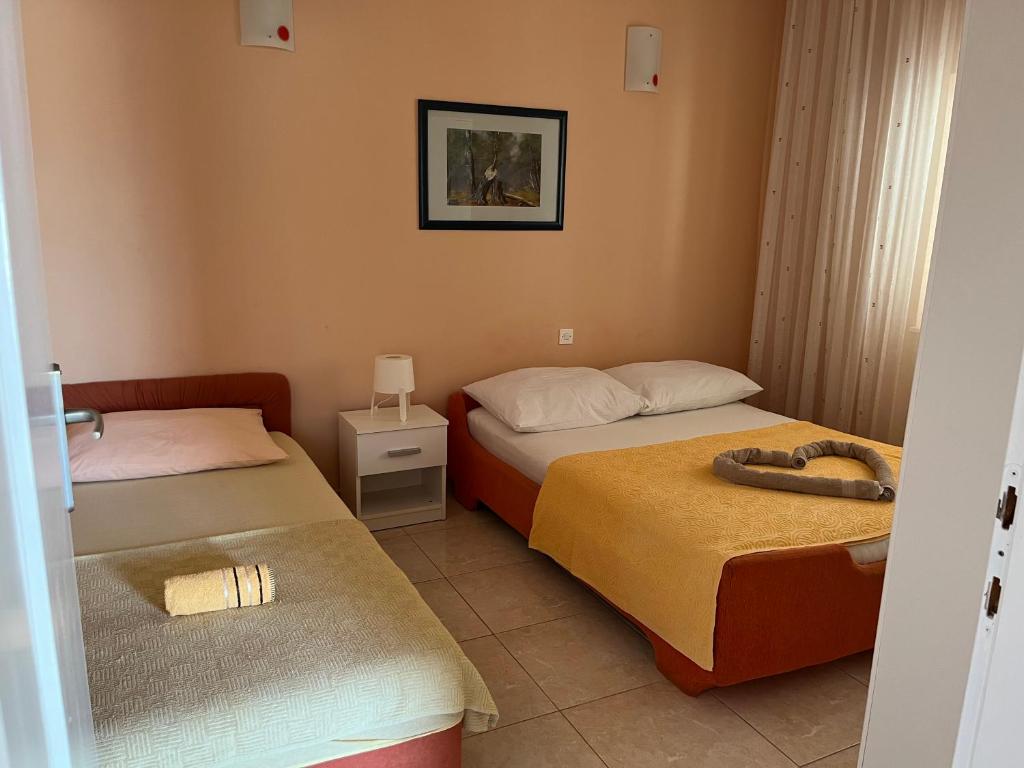 a hotel room with two beds and a picture on the wall at Apartments Pralija in Sevid