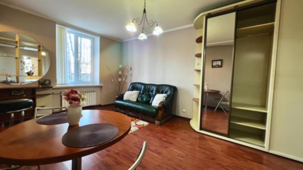 sala de estar con mesa y sofá en Cozy Apartment In City Center, Chisinau en Chisináu