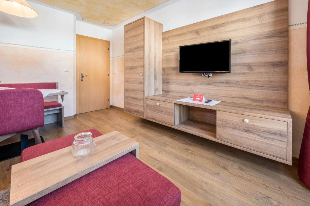 a hotel room with a tv on a wall at Haus zur Vogelweide App 4 in Dobbiaco
