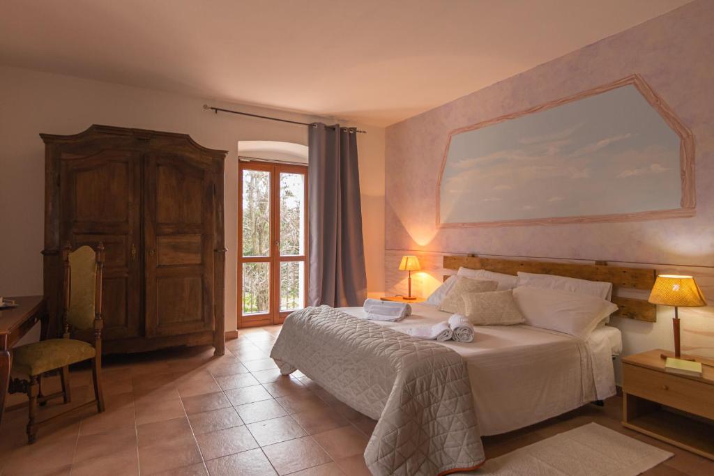 a bedroom with a bed with a large painting on the wall at Hotel Locanda Minerva in Monteleone Rocca Doria