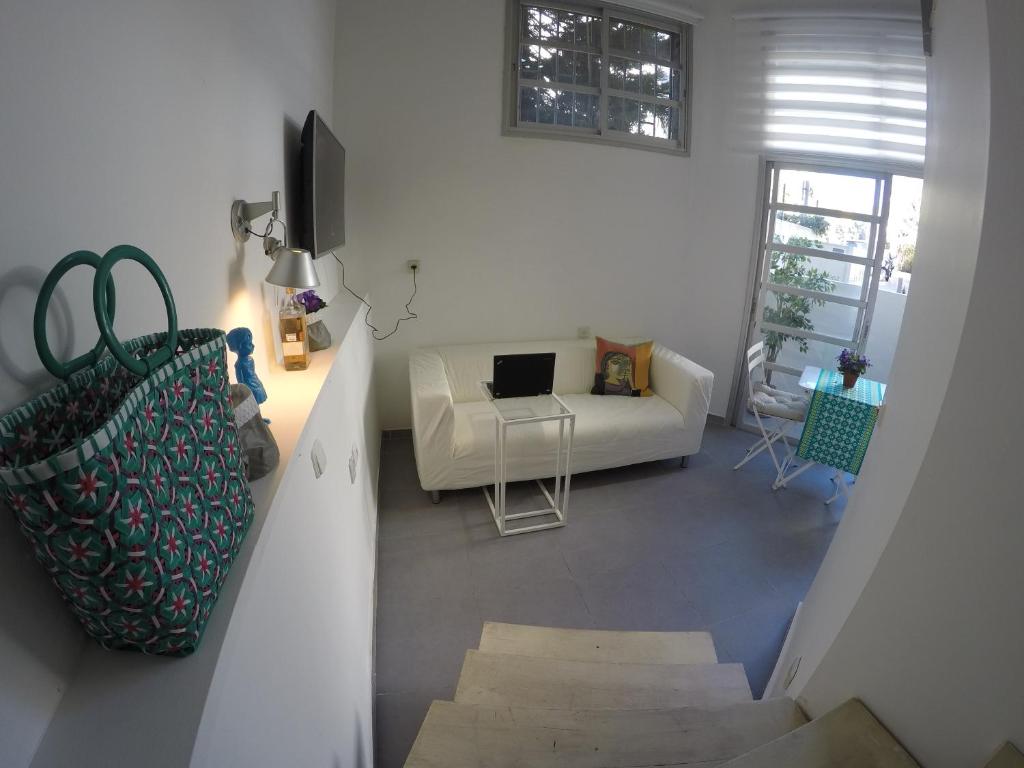sala de estar con sofá blanco y mesa en Tel Hai City Studio Center Apartment By Nimizz, en Tel Aviv