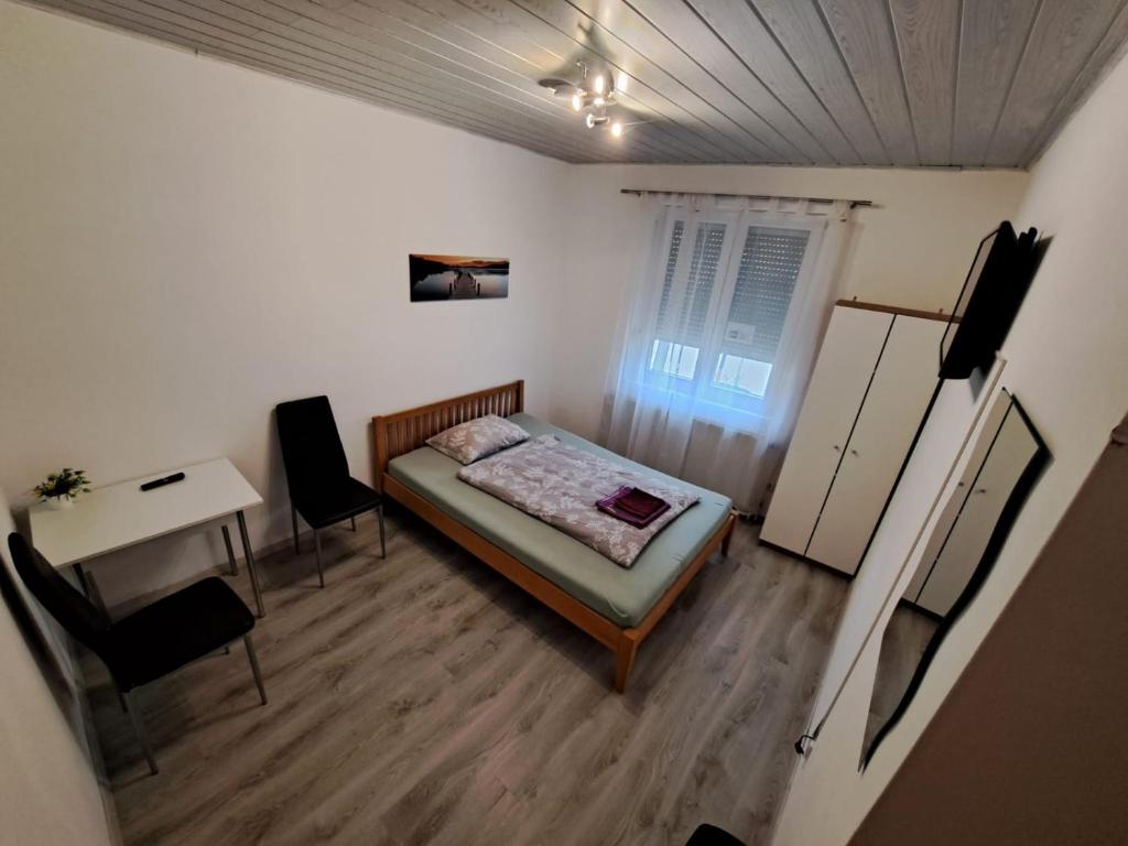 een kleine slaapkamer met een bed en een bureau bij HostelHollabrunn in Hollabrunn
