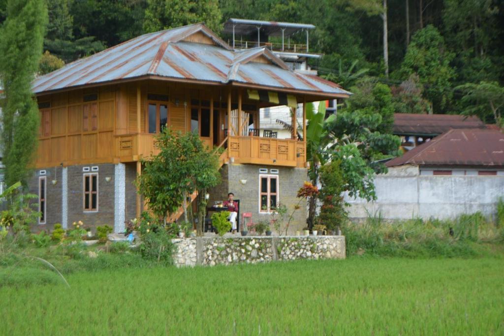 una casa con techo de metal en la parte superior de un campo en THE SINGKI HOME FAMILY en Rantepao
