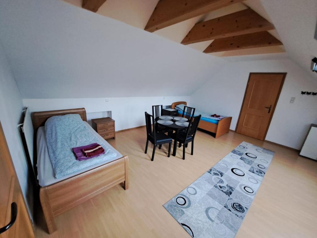 sypialnia z łóżkiem, stołem i krzesłami w obiekcie HostelHollabrunn w mieście Hollabrunn
