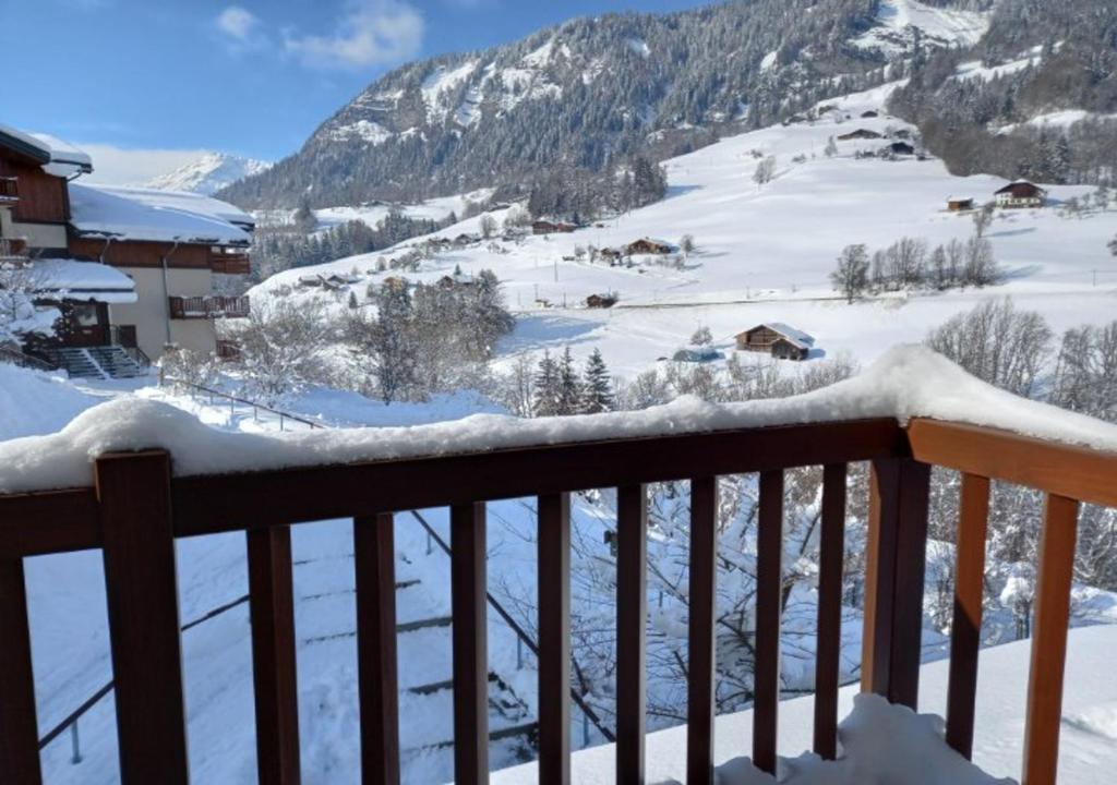 a snow covered balcony with a view of a mountain at Les Chevreuils des Evettes in Flumet