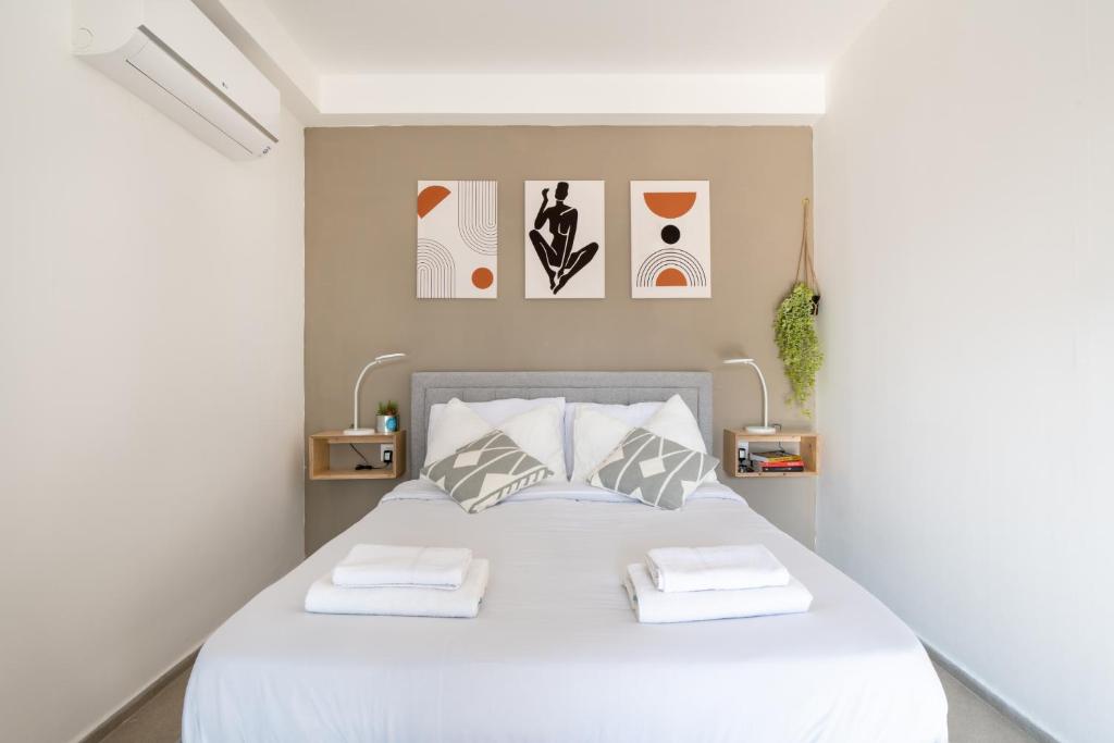 una camera con un letto bianco con due cuscini di Haifa PORT Patio Apartment 2 BDRM a Haifa