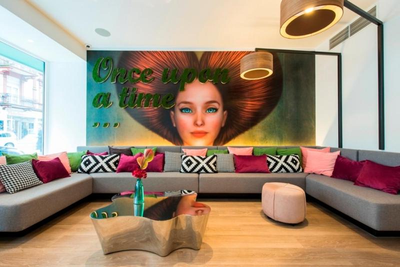 a living room with a couch and a poster of a woman at Ambassador Hotel in Frankfurt/Main