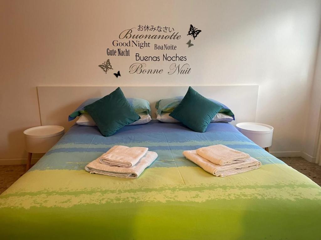 Una cama con dos toallas encima. en San Pellegrino Solarium Apartment, en San Pellegrino Terme