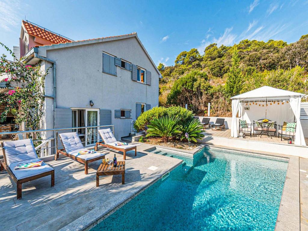 een villa met een zwembad en een huis bij Villa Angela in Lastovo