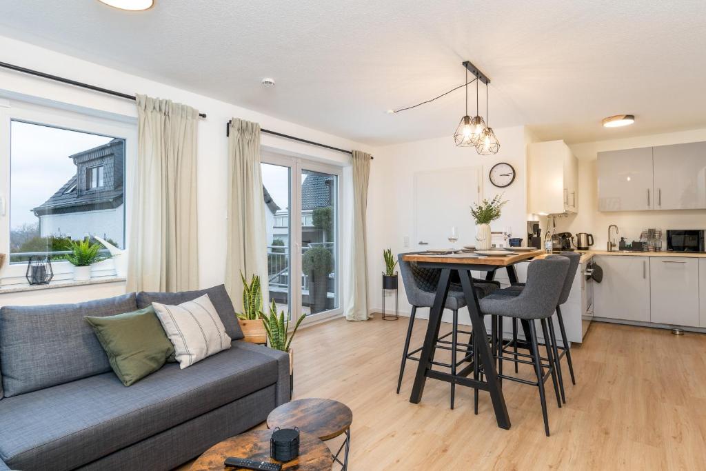 a living room with a couch and a table and a kitchen at EasyGreen moderenes Appartment - Essen by EasyHood in Essen