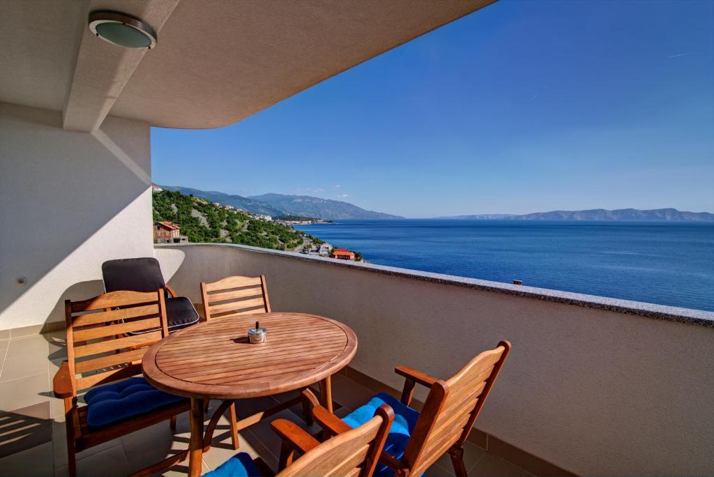 einen Tisch und Stühle auf einem Balkon mit Meerblick in der Unterkunft Apartments Maris Senj 2 in Vrataruša