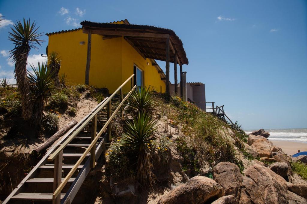 un edificio amarillo en una colina junto a la playa en Meliodas, en Aguas Dulces
