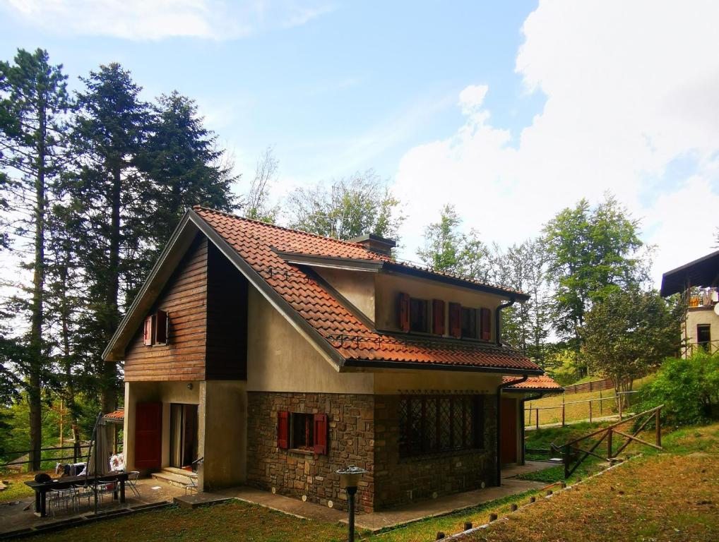 una casa con un tetto di tegole sopra di Villa di montagna sul cammino della Via degli Dei 